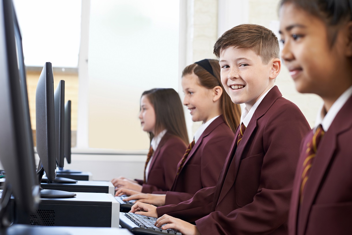 online naplan practice vs workbooks smiling child student at computer